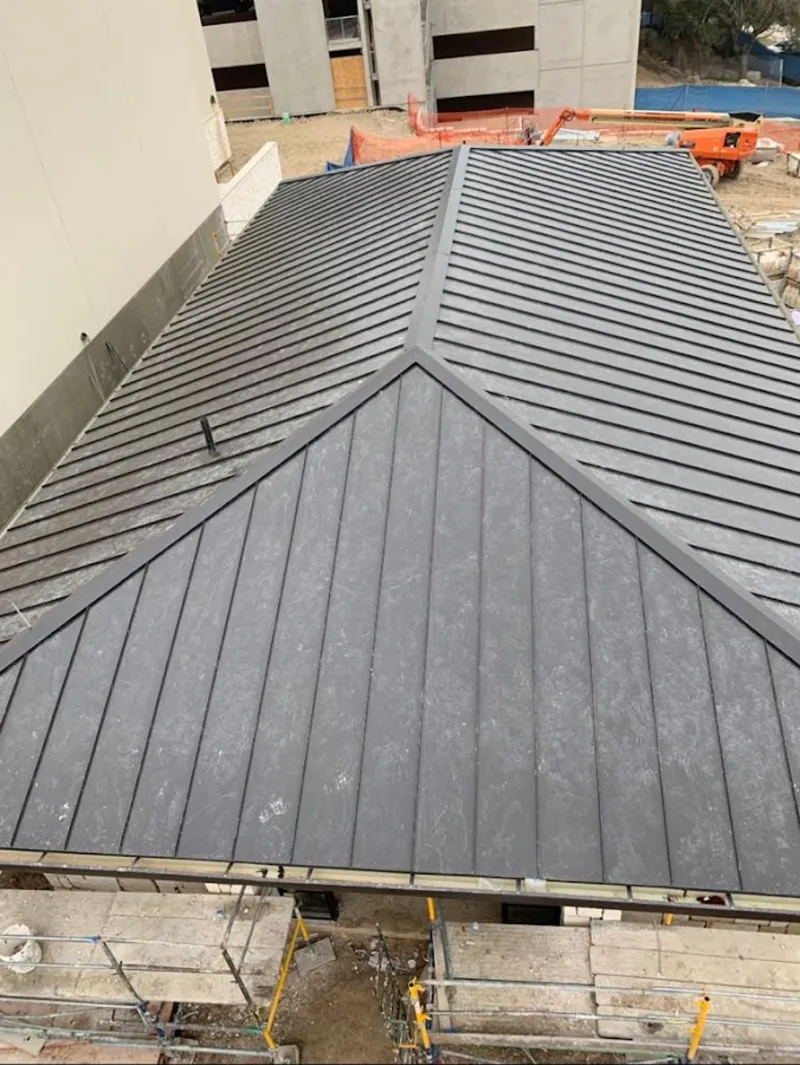 Commercial metal roof construction with crane equipment in Laramie